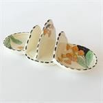 White toast rack with orange and green floral pattern.